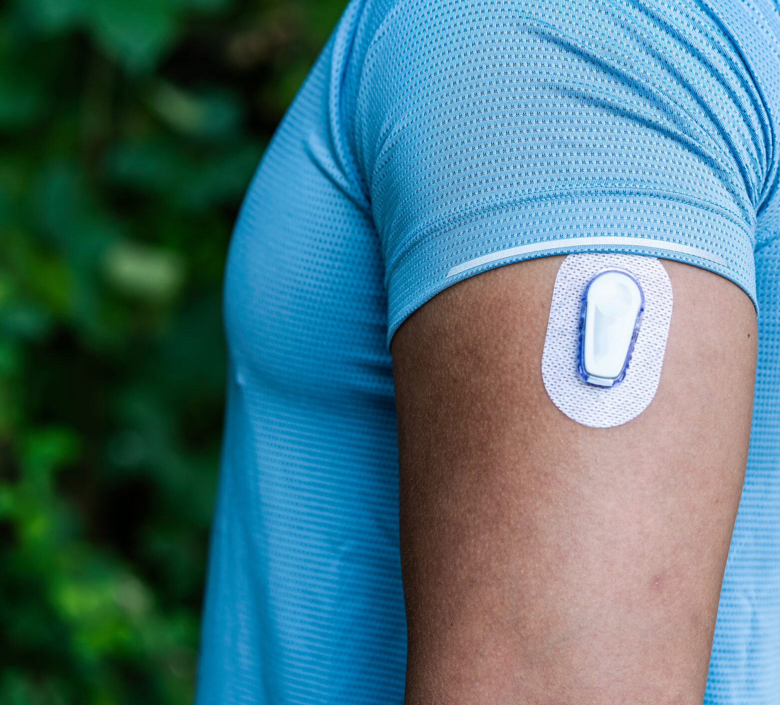 Man in blue exercise shirt with CGM (Dexcom) on his arm